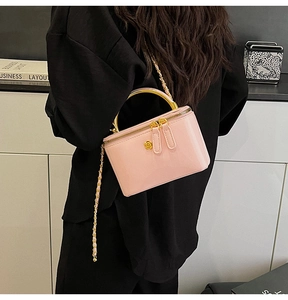 Détail du mini sac carré rose brillant avec poignée en métal doré et bandoulière