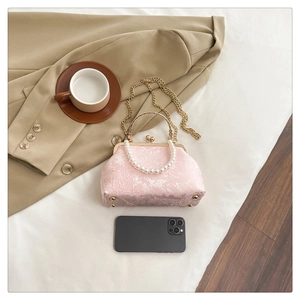 Detail of pink floral jacquard mini bag with pearl handle and metal chain compared to phone
