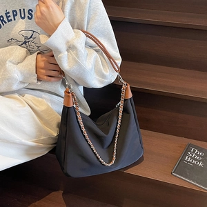 Black large capacity nylon tote bag with brown leather accents and chain shoulder strap