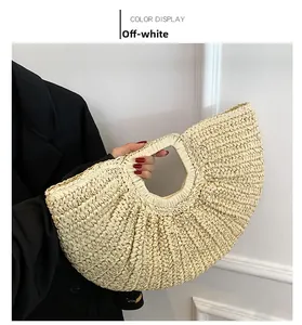 Handheld detail of a cream white French vintage woven straw bag in a fan shape