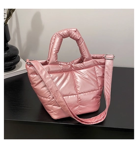 Close-up of pink metallic quilted down tote bag with plush texture and silver hardware