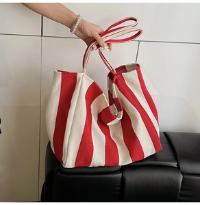 Close-up of red and white vertical striped canvas tote bag with textured fabric detail