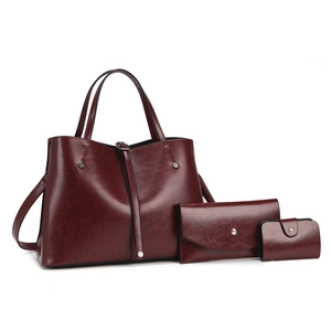 Three-piece set of wine red faux leather tote bag, clutch, and card holder on white background