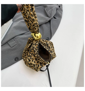 Détail du sac à main tendance en toile léopard avec une grande boucle décorative en métal doré
