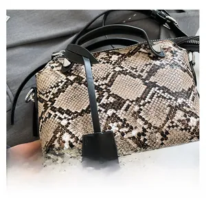 Detail shot of brown snakeskin pattern texture with black leather handle and silver rivets