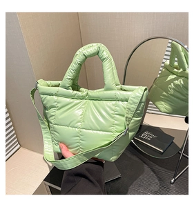 Close-up of mint green quilted puffer tote bag with side mirror reflection detail