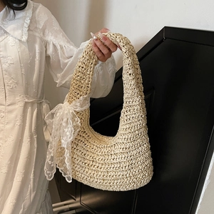 Chic beige straw shoulder bag with a large lace bow for elegant summer vacation vibes