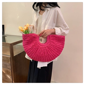 Detail of rose red woven crescent bag with round handle and yellow tulip decoration