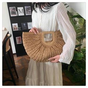 Detail of hand-woven straw handbag with rectangular cutout handle for summer fashion