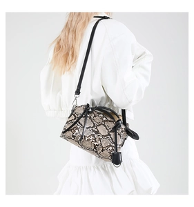 Detail of snake pattern crossbody bag with knotted leather decor and adjustable strap