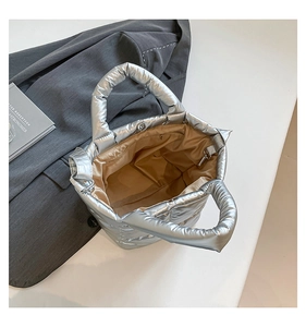 Detail of silver quilted tote bag with magnetic clasp and champagne satin lining interior
