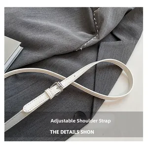 Detail of adjustable white lychee pattern leather shoulder strap with silver metal buckle