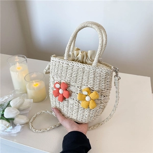 Handwoven straw bucket bag with floral accents and a drawstring lining for summer