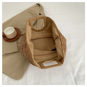 Detail of hand-woven straw tote bag with fabric lining, zipper pocket and interior space
