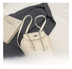 Detail shot of heart-quilted white PU leather backpack with chain drawstring and silver lock