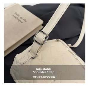 Detail of adjustable shoulder strap with silver buckle on heart quilted white backpack