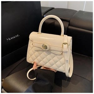 Détail du sac à main matelassé blanc crème avec fermoir doré et texture en simili cuir