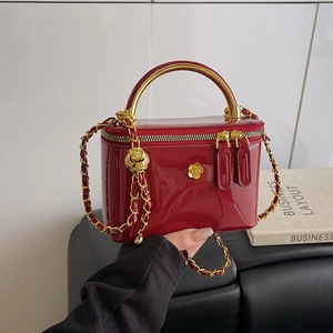 Sac à main en cuir verni rouge avec poignée dorée, logo camélia et chaîne