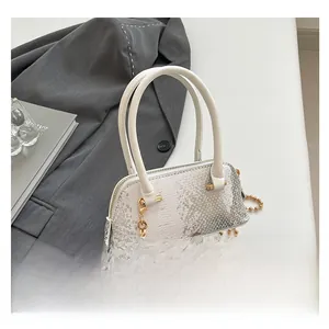 Detail of silver snake-textured mini shell bag with gold chain on grey blazer