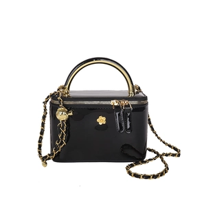 Sac bandoulière en cuir verni noir avec camélia doré et bandoulière chaîne