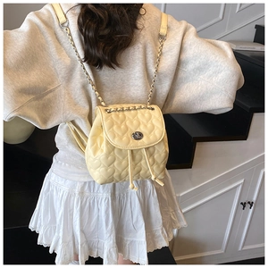Detailed shot of cream mini backpack featuring heart stitching and silver chain straps