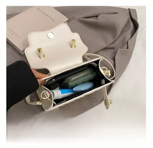 Vue intérieure du sac bandoulière beige matelassé avec espace pour téléphone et maquillage