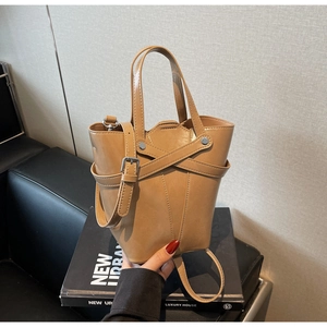 Detail of vintage caramel bucket bag showing cross decorative straps and metal buckle