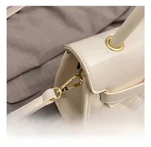 Vue détaillée des crochets métalliques dorés et des finitions sur un sac à main matelassé