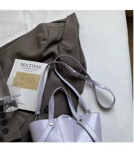 Detail of adjustable long shoulder strap and lavender leather texture of the bucket bag