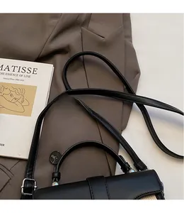 Détail de la bandoulière réglable en cuir et des boucles argentées du sac de selle noir