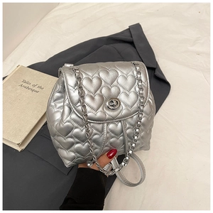 Macro shot of silver quilted heart pattern backpack with metal chain strap and twist lock