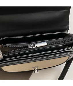 Vue détaillée de la fermeture éclair en métal et coutures bicolores du sac de selle