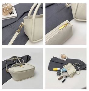 Detail view of white lychee leather handbag showing golden zippers and daily essentials