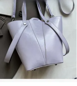 Detail of lavender bucket bag showing soft leather texture and bottom metal studs