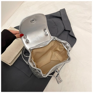 Silver quilted backpack detail showing drawstring closure and brown fabric interior lining