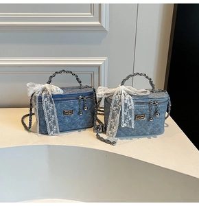 Detailed view of denim quilted mini bags featuring large white lace bows and metal chain