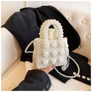 Détail du sac à main en perles fait main avec pochette en satin sur une veste noire