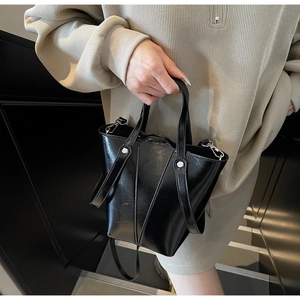 Detail of black vintage bucket bag with glossy finish and silver rivet metal studs