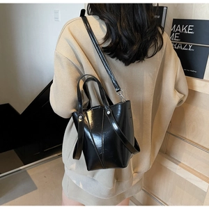 Detailed view of black geometric bucket bag showing PU leather texture and stitching