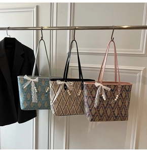 Detailed view of woven tote bags with diamond patterns and decorative pearl chain straps