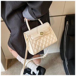 Détail du sac en cuir PU matelassé crème avec fermoir doré porté par un mannequin