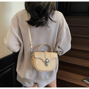 Détail de la sacoche en cuir avec coutures et fermeture à boucle en métal rétro chic