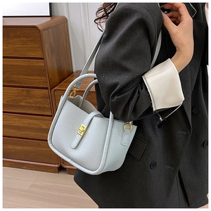 Detail of light blue lychee pattern leather tote bag with elegant golden hardware lock