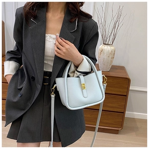 Detail of light blue pebble leather handbag with gold twist lock and shoulder strap