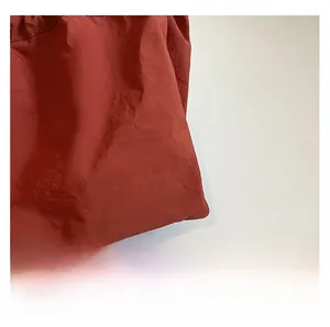 Vue macro de la texture du tissu en nylon rouge plissé avec une finition brillante pour sacs