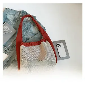 Détail du sac bandoulière en maille rouge et blanc avec cordon de serrage plissé
