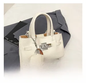 Détail du sac à main blanc en cuir grainé avec fermoir argenté et breloque cœur