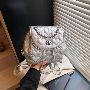 Silver mini backpack featuring heart quilted patterns and metallic chain handle