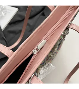 Close-up of smooth silver metal zipper and fine stitching on a pink faux leather handbag