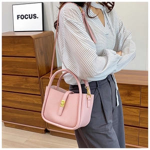 Detail of light pink pebble leather handbag with gold twist lock and dual handles